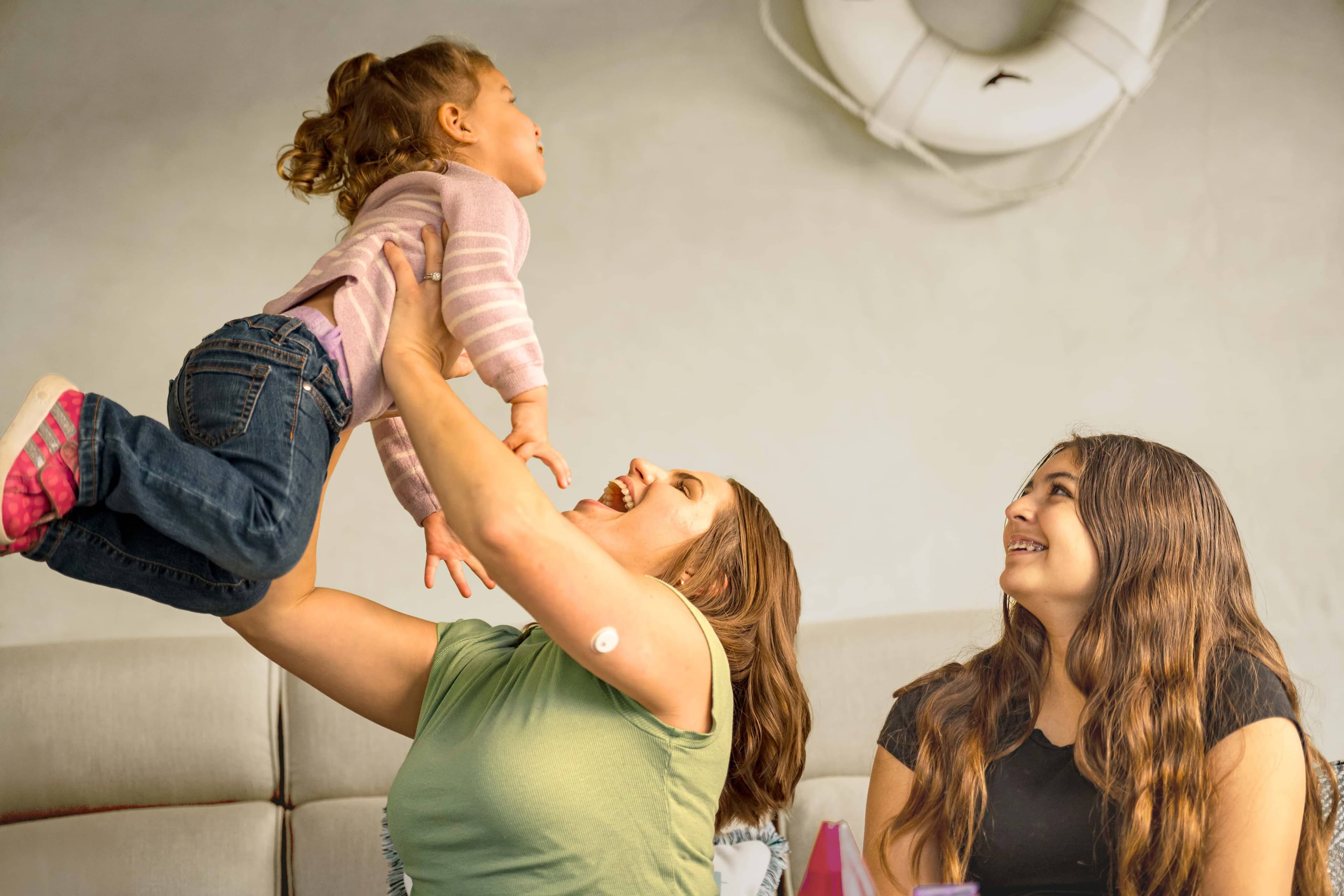 Woman laughing with arm raised showing the Instinct™ sensor worn on her upper arm