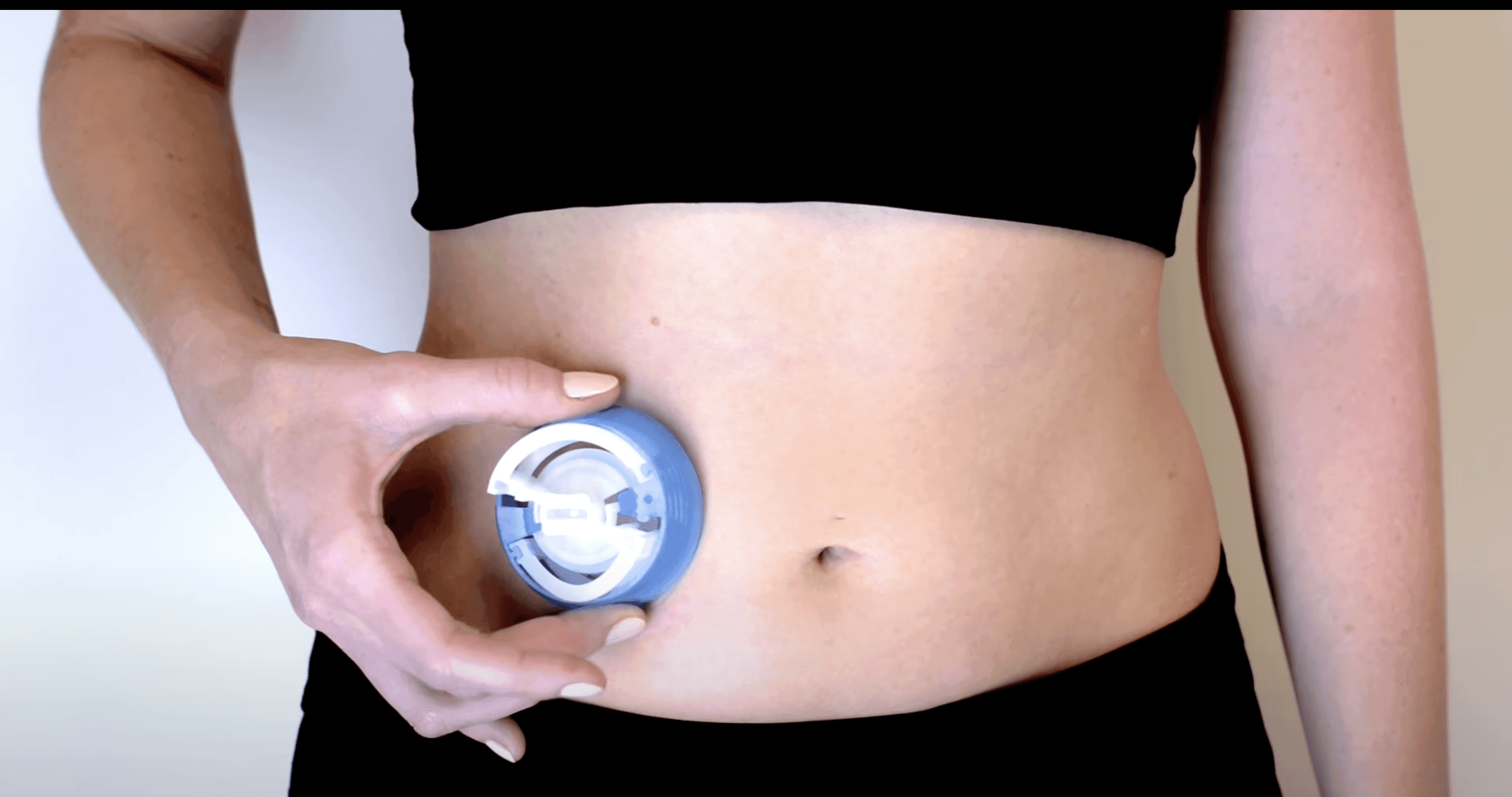 Person holding the i-Port Advance applicator against their abdomen
