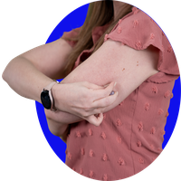 Person inserting a glucose sensor into the back of the upper arm.
