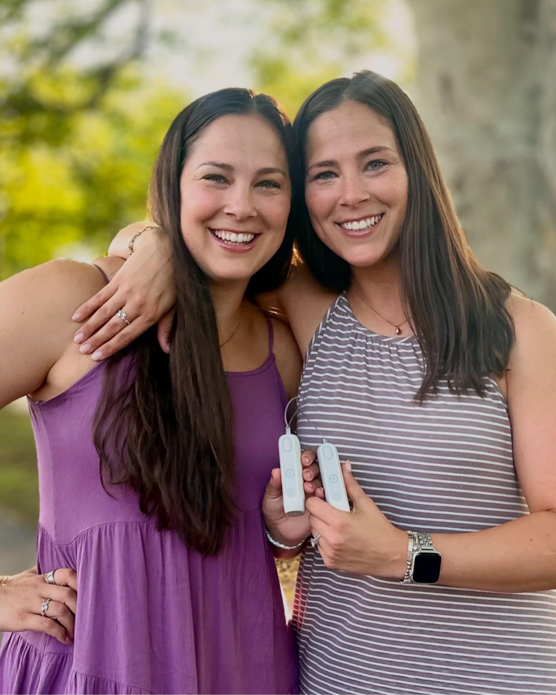 MiniMed employee Emily with twin sister Ashley holding their MiniMed Flex pumps