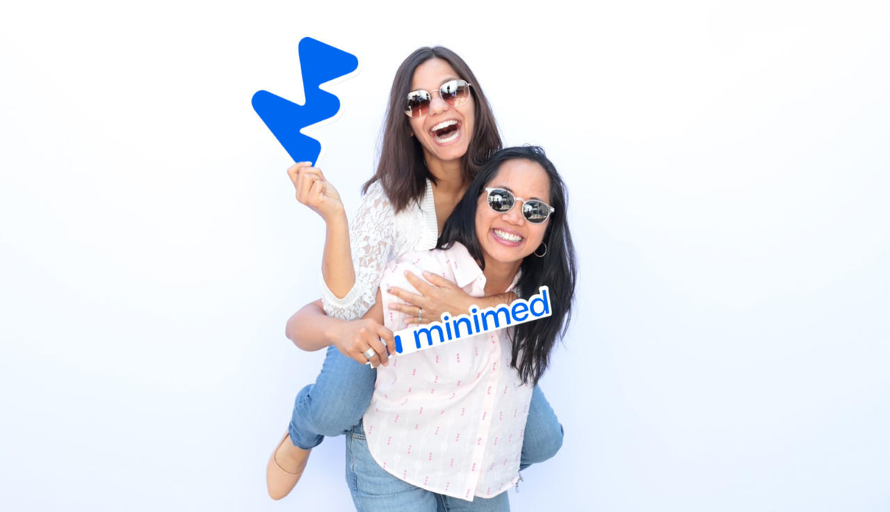 Smiling employees holding MiniMed signs
