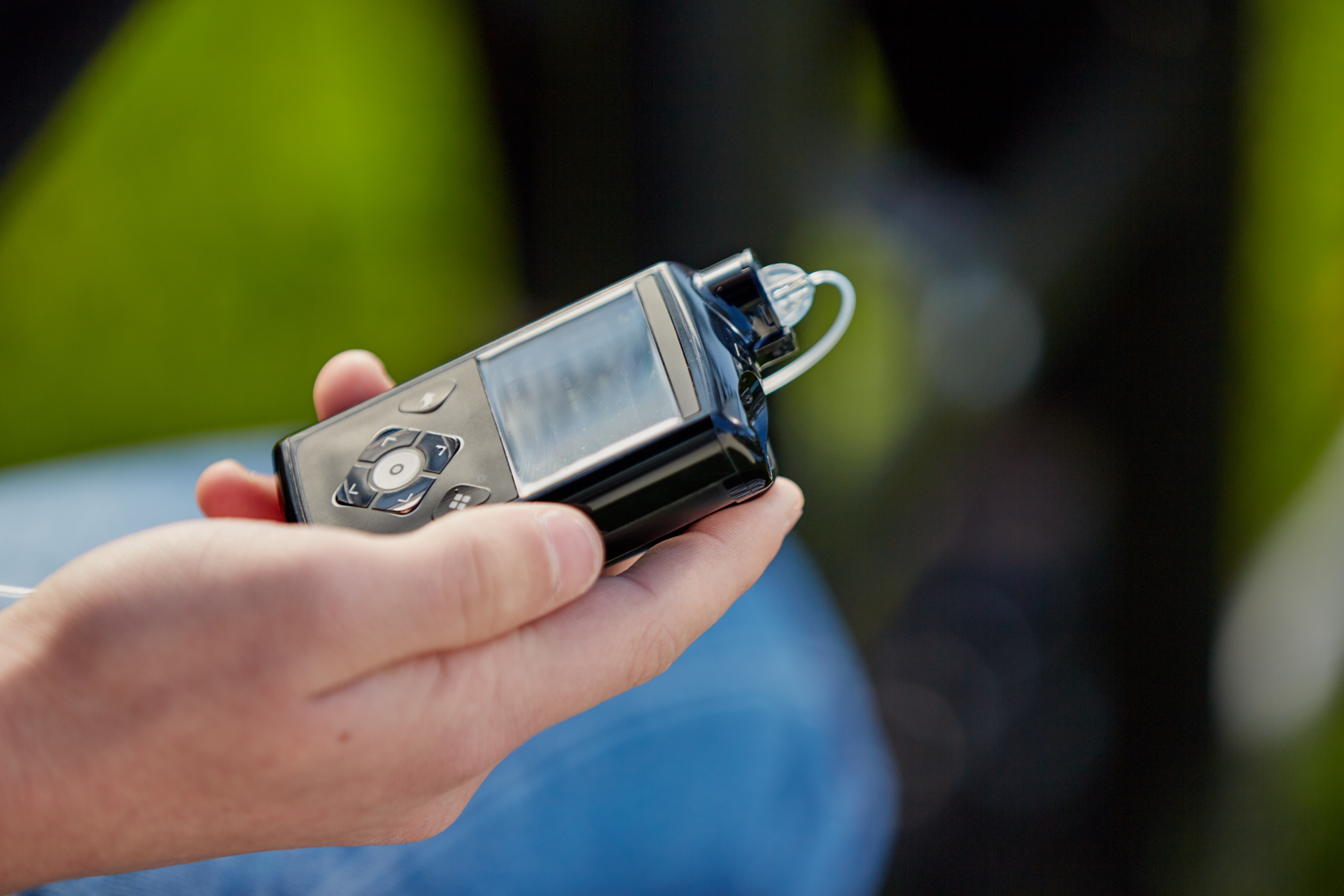 Close up MiniMed 780G pump in hand