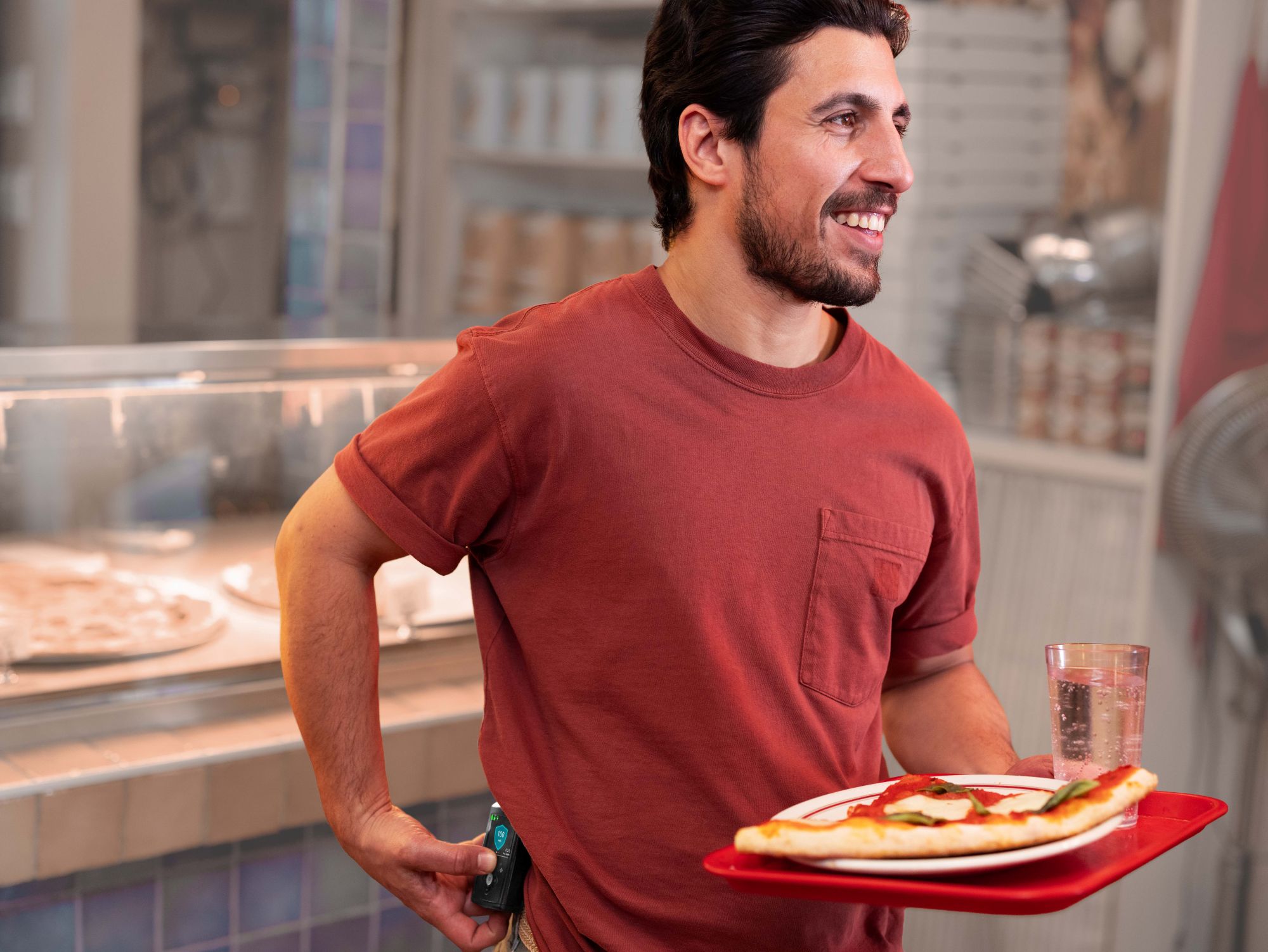 Man wearing MiniMed 780G holding pizza