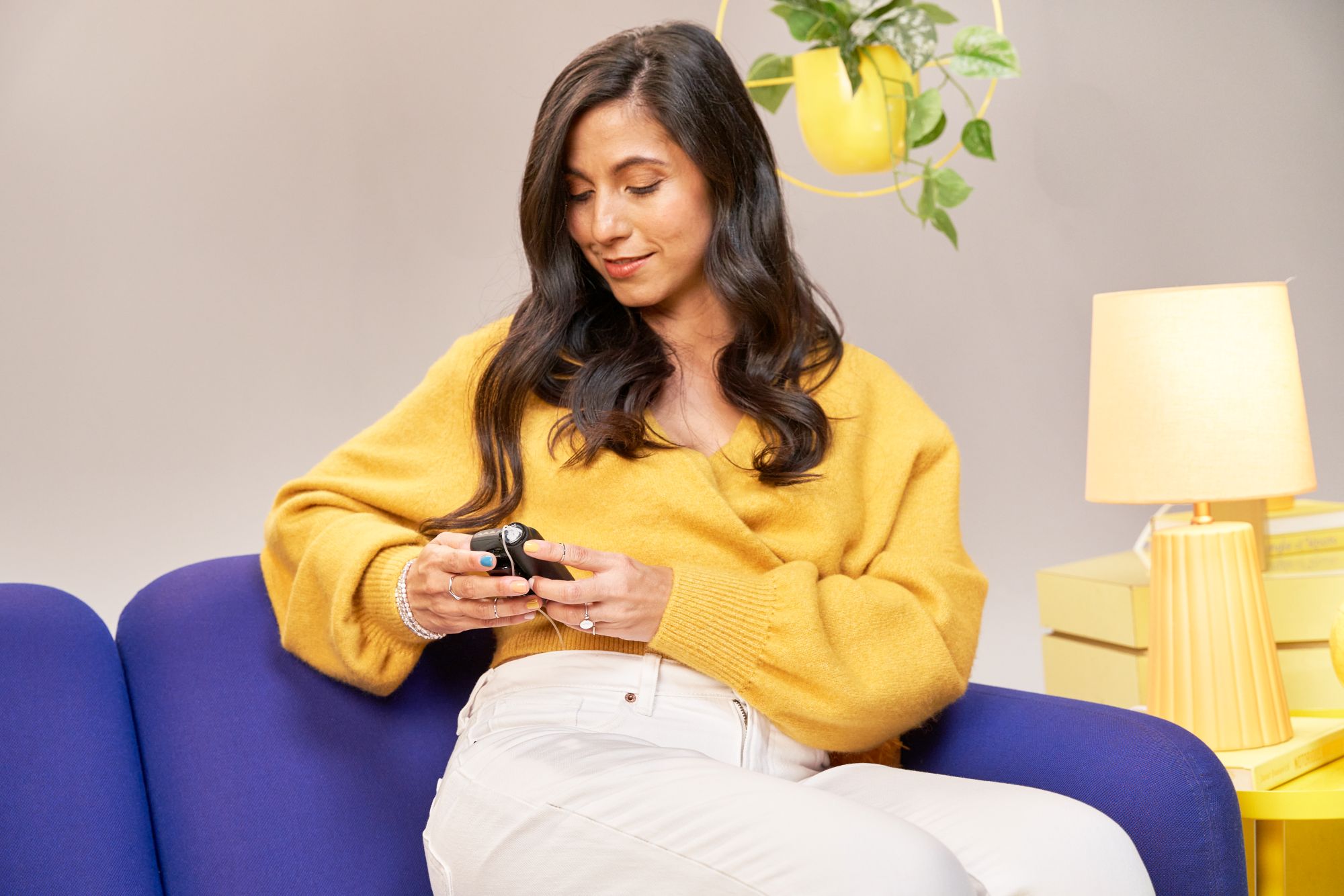 MiniMed Champion Daniela wearing yellow using 780G on couch